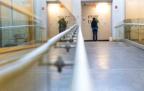 a student stands at a memorial wall