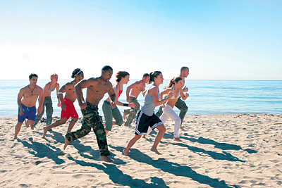 Photo of a group of people running on the beach.