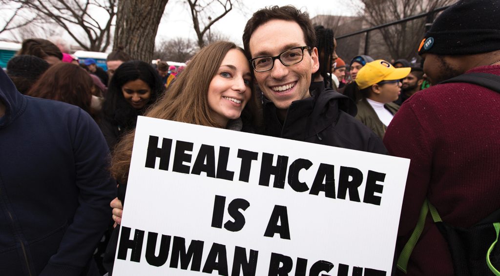 Photo of Kira Ganga Kieffer ’08 and Aaron Eisman ’08, at a rally with a sign that says 