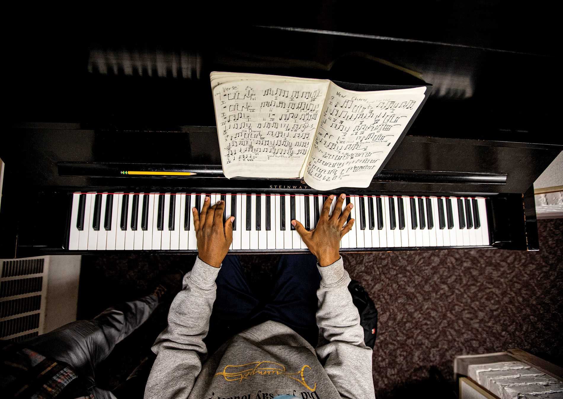 Image from above of Derrick Pennix playing the piano