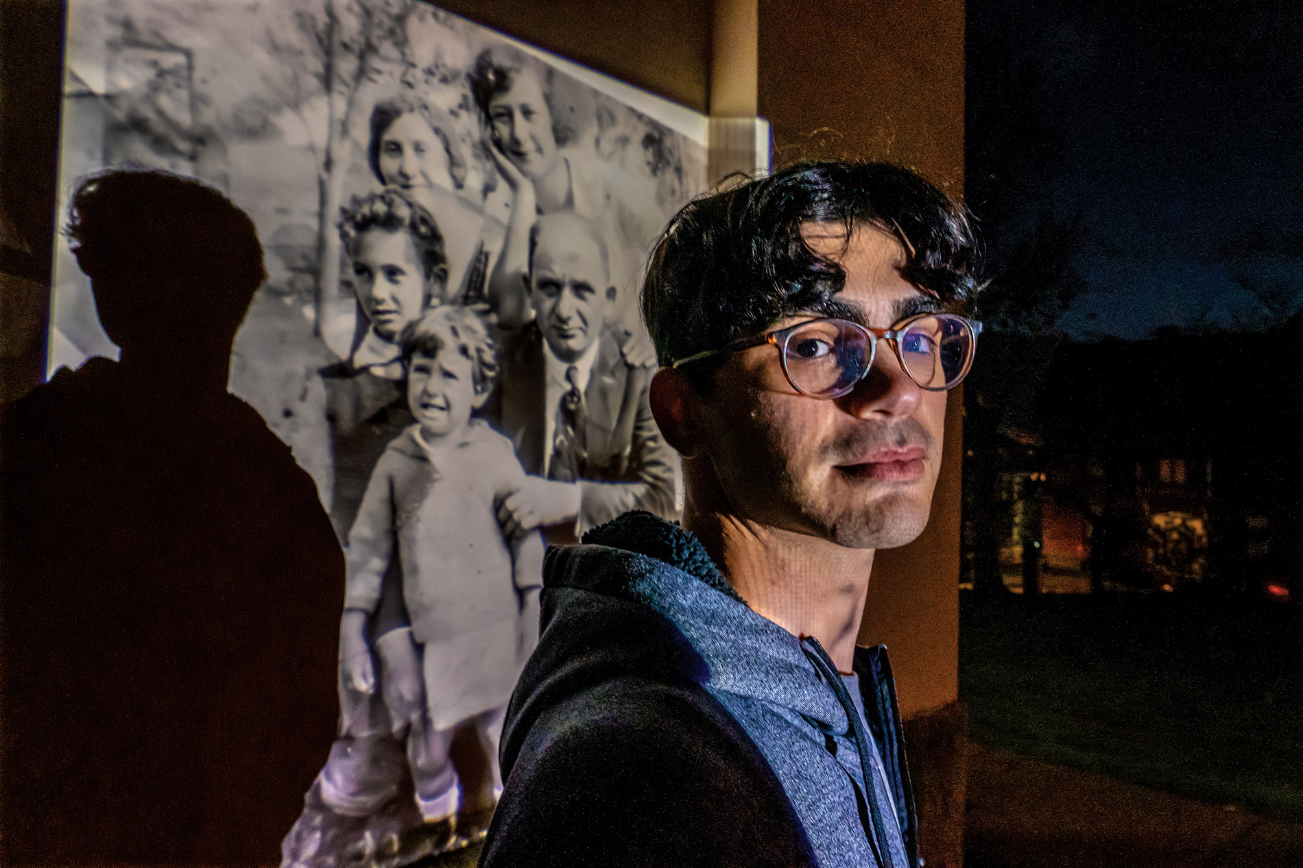 Image of Garfinkle with a photo projected behind him on a wall of his great-great-grandparents and their children, including his namesake, Jack.