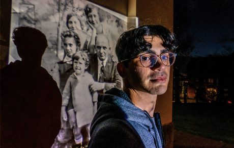 Image of Garfinkle with a photo projected behind him on a wall of his great-great-grandparents and their children, including his namesake, Jack.