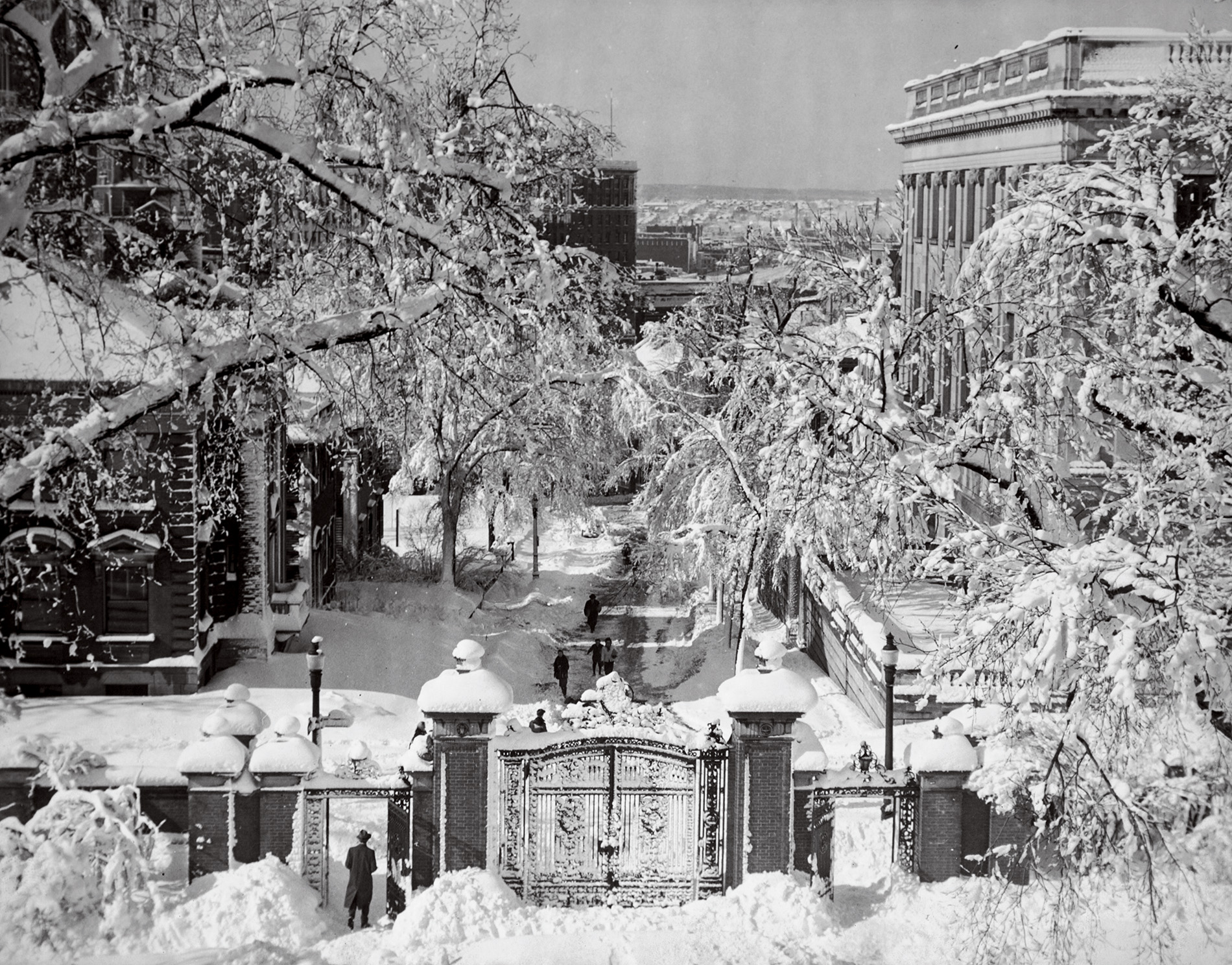 Image of the Van Wickle gates covered in snow in the early 20th century looking down College Hill