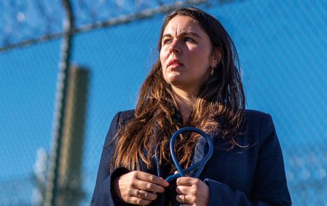 An image of Rachel Bedard holding a stethoscope outside of a prison