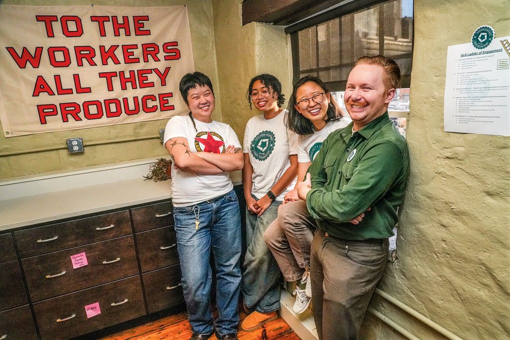 An image of Jo Ouyang, Yasmine Abdelaziz, Anna Ryu, and Michael Ziegler, with a sign in the background that states 