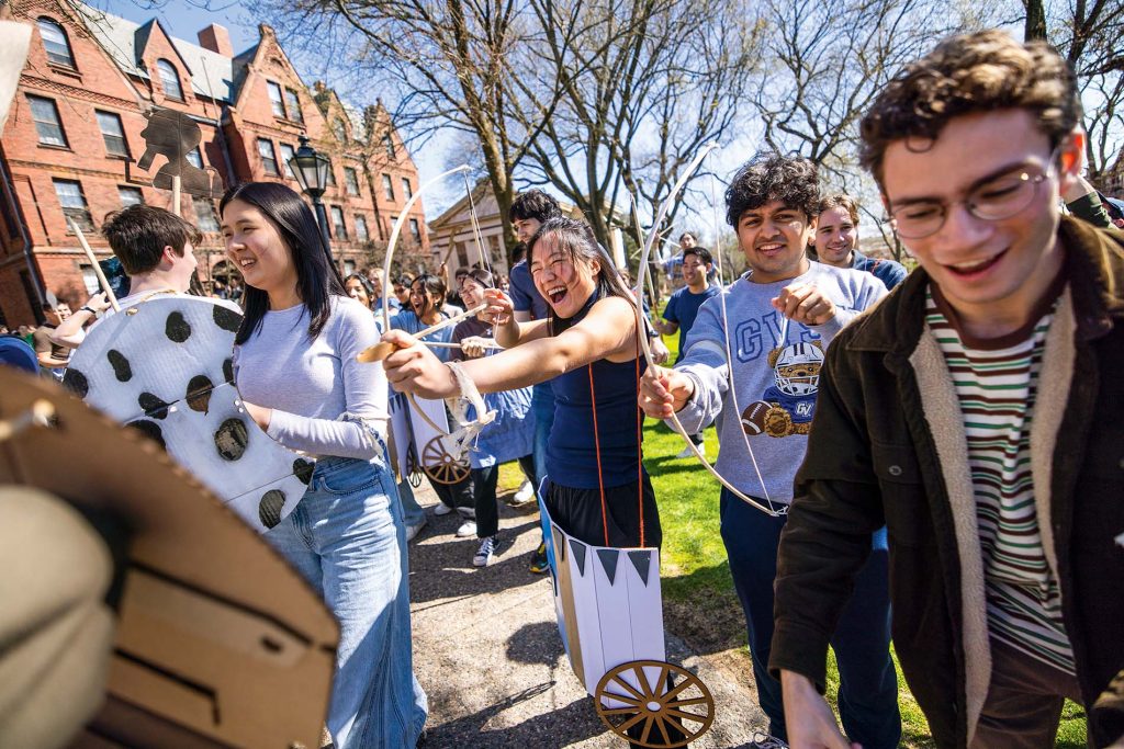 An image of students on the green with bows and arrows and dressed like ancient Egyptians